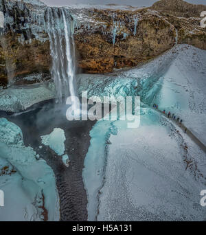 Seljalandsfoss im Winter, einem einzigartigen Wasserfall mit einem Wanderweg hinter sich. Dieses Bild wird mit einer Drohne geschossen. Stockfoto