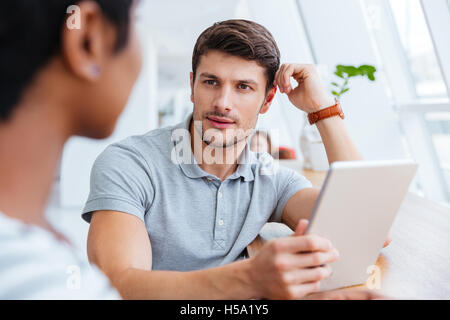 Zuversichtlich Geschäftsmann und attraktive Geschäftsfrau arbeiten mit Tablet und trinken Kaffee zusammen im café Stockfoto