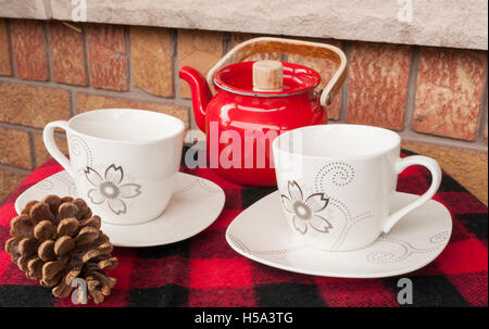Elegante Teetassen set für zwei Personen mit roten Teekanne. Gesetzte Außenseite auf Ziegel Veranda. Stockfoto