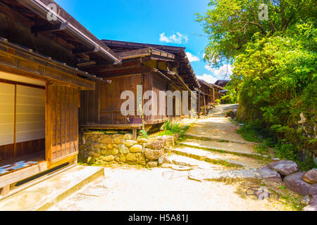 Eine Reihe von idyllischen Holzhäusern und unbefestigte Straße restauriert zu einem alten timey japanische Landschaft Gefühl entlang der Nakasendo in Stockfoto