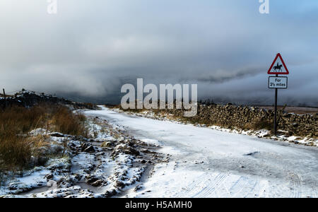 Rutschig wird für alle Benutzer auf dem Schnee bedeckt Kohle Straße oberhalb Dentdale, Cumbria, Yorkshire Dales National Park, England, UK Stockfoto