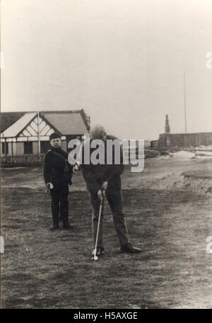 Dieses Bild zeigt einen Golfer mit seinem Caddy, eine wichtige Partnerschaft im Golfsport. Der Caddy hilft dem Golfer bei der Auswahl des Golfschlägers und bietet Ratschläge während des Spiels, eine wesentliche Rolle im professionellen Golf. Stockfoto