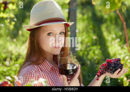 Schöne junge blonde Frau, die Ernte der Trauben im Weinberg im freien Stockfoto