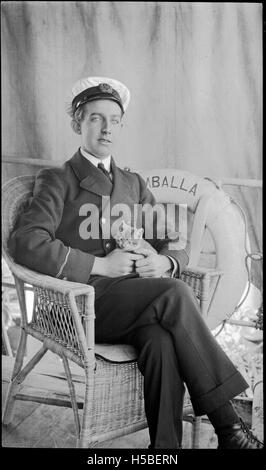 Dieses Foto zeigt einen Lehrling an Bord der SS Umballa in den 1910er Jahren, der ein Kätzchen hält. Das Bild fängt einen Moment des täglichen Lebens an Bord eines historischen Schiffes ein. Stockfoto