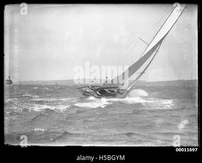 Eine Yacht segelt im Hafen von Sydney mit dem berühmten Opernhaus von Sydney und der Harbour Bridge im Hintergrund. Das Bild fängt die Eleganz und Schönheit des Segelns in einem der berühmtesten Häfen der Welt ein. Stockfoto