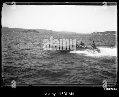 Das Motorboot mit dem Namen QUEENSLAND nimmt 1912 an der Motor Boat Championship im Hafen von Sydney Teil. Diese Veranstaltung spiegelt den nautischen Sport des frühen 20. Jahrhunderts und den Aufstieg des motorisierten Bootstourismus wider. Stockfoto