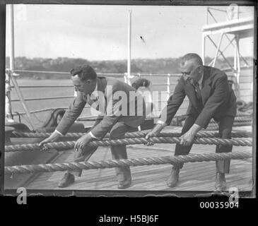 Zwei Männer ziehen an Seilen an Deck der SS Runen, 1920er Jahre Stockfoto