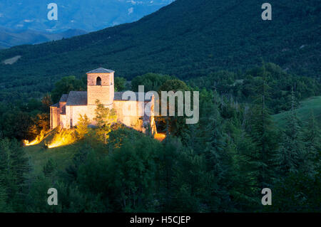 Französisch, Landschaft. Die romanische St.-Peter-Kirche, in der Abenddämmerung, beleuchtet mit Blick auf die zerklüftete Berglandschaft des Vercors. La Drôme, Frankreich. Stockfoto