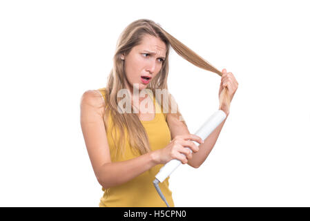 Junge Frau Schäden an ihrem Haar mit Begradigung Eisen Stockfoto