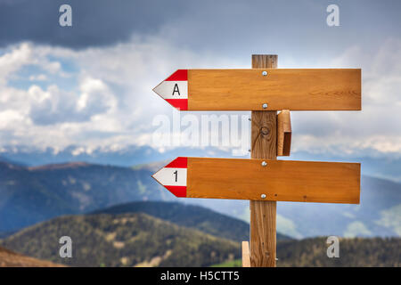 Leere Wegweiser aus Holz mit schlechtem Wetter in den Bergen Stockfoto