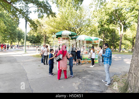 Menschen sammeln rund um das Essen / Eis Warenkorb auf dem Bürgersteig der Central Park in New York City Stockfoto