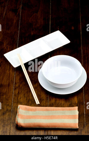Leere Schüssel auf Teller mit Ess-Stäbchen, Napery. Stockfoto