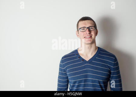 Porträt von einem fröhlichen jungen Mann mit Brille Stockfoto