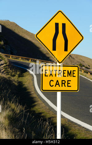 Kurvenreiche Straße mit "Straße verengt" und "Vorsicht" Verkehrszeichen, Te Mata Peak, Hastings, Hawke Bay, North Island, Neuseeland Stockfoto