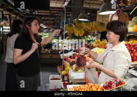 Einen bunten Obst und Gemüse Markt im Bereich Tianzifang, kauft hier eine argentinische Frau einige Trauben an einem Obststand. Shanghai. Stockfoto