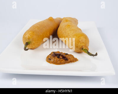 Chili bajji mit Zwiebelchutney ein südindischer Snack auf einer Tauchplatte mit Holzhintergrund Stockfoto