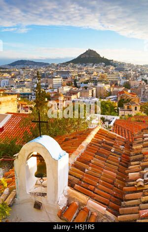 Lycabettus-Hügel und eine kleine griechisch-orthodoxe Kirche in Anafiotika, Athen. Stockfoto