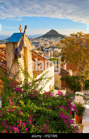 Lycabettus-Hügel und eine kleine griechisch-orthodoxe Kirche in Anafiotika, Athen. Stockfoto