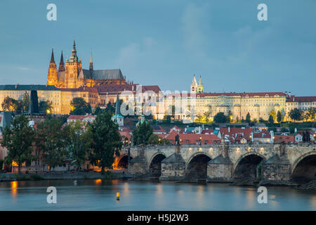 Am Abend auf der Karlsbrücke über die Moldau in Prag, Tschechische Republik. Hradschin Burg dominiert die Skyline. Stockfoto