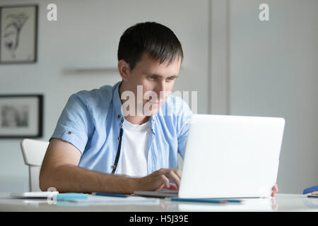 Porträt des jungen Menschen arbeiten am Schreibtisch mit laptop Stockfoto