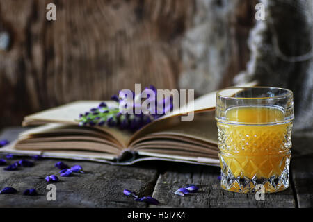 Retro-Buch und ein Glas Orangensaft morgens Stockfoto