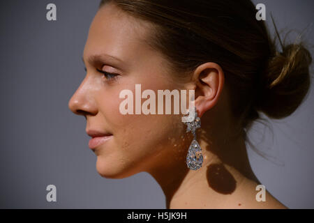 Ein Christie Mitarbeiter modelliert die Miroir de L'Amour Diamantohrringe in ihrer London-Showroom. Stockfoto