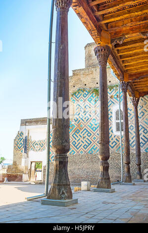 Der Blick durch die geschnitzten Säulen der Moschee die Veranda an der zerstörten Wand Dorus-Saodat Mausoleum, Hekime Imam Komplex, Shak Stockfoto