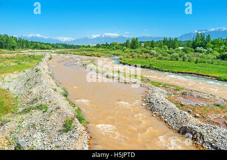 Der Yakabag Darya Fluß fließt zwischen Wiesen und Wäldern mit den verschneiten Bergen Gissar Bereich des Pamir-Alay Stockfoto