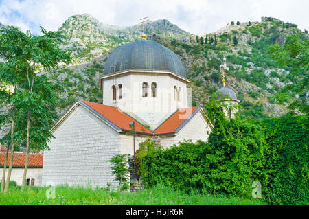 Die Kuppel der serbischen orthodoxen Kirche St. Nicolas mit den nebligen Bergen und den Wällen der Festung St. John Stockfoto