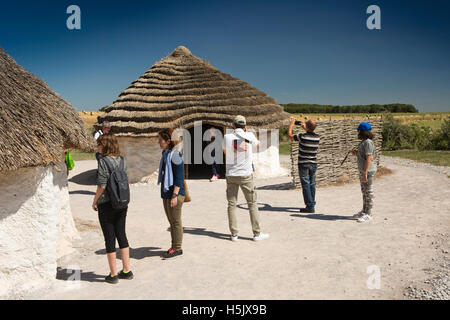 Großbritannien, England, Wiltshire, Stonehenge Visitor Centre Besucher im rekonstruierten neolithischen Dorf Stockfoto