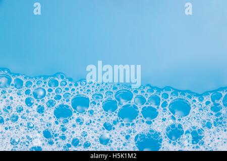 Zusammenfassung Hintergrund von Seifenschaum, Seifenlösungen, Dusche. Blauer Hintergrund. Soft-Fokus, Makro-Ansicht Stockfoto