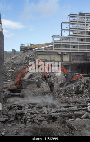 Schwere Anlagen, Maschinen ruinieren und Gebäude auf einer innerstädtischen Abbruchbaustelle, der aussieht wie ein Kriegsgebiet. Stockfoto