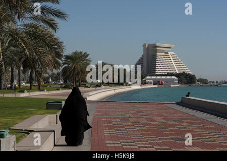 Arabische Frau tragen traditionelle schwarzen Kleidung gehen für einen Spaziergang entlang der Corniche vor dem Sheraton Hotel Stockfoto