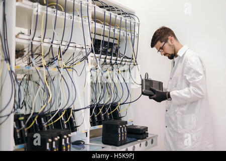 Netzwerktechniker testen Modems in Fabrik Stockfoto