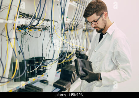 Netzwerktechniker testen Modems in Fabrik Stockfoto