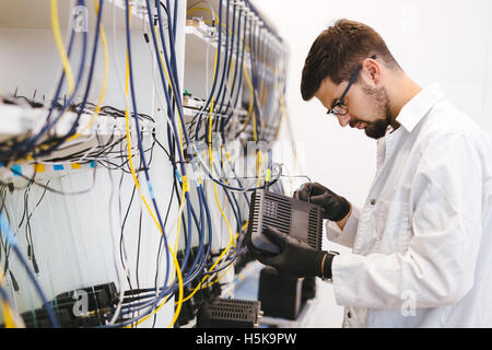 Netzwerktechniker testen Modems in Fabrik Stockfoto