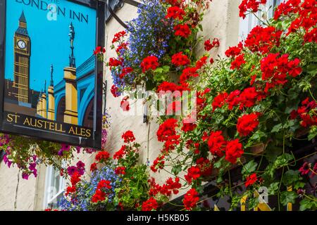 ein Pub Schild in Padstow, Cornwall - The London Inn mit weißen Wänden und roten und blauen hängenden Körben außerhalb Stockfoto