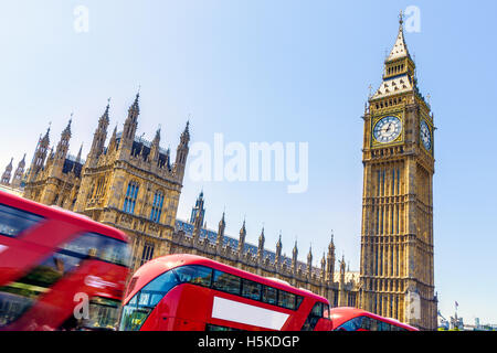 Big Ben und House of Parliament in London mit roten Busse vorbei in Bewegung an einem wolkenlosen Tag Stockfoto