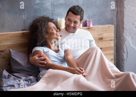 Glückliches Paar, das zusammen im Bett chillen Stockfoto