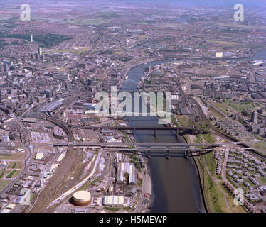 Eine Luftaufnahme des Flusses Tyne aus dem Jahr 1983, die wichtige Sehenswürdigkeiten wie die Tyne Bridge, die Swing Bridge und verschiedene Brücken zwischen Newcastle und Gateshead zeigt. Der Blick fängt die städtische Landschaft ein, einschließlich Eisenbahnen, Parks und Quais. Stockfoto