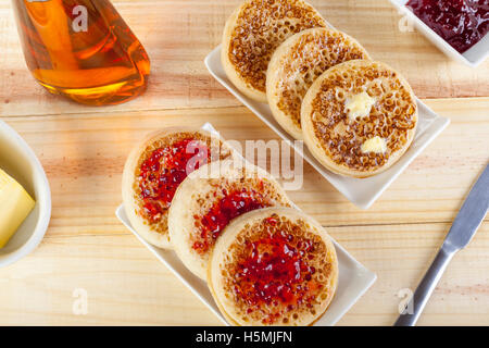 Frisch gerösteten Fladenbrot auf rechteckige Servierplatten mit Butter und Marmelade auf eine Ländertabelle angelegt Stockfoto