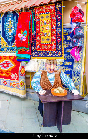 Die Puppe von Georgisch, am Tisch sitzen und Essen Khinkali gefilzte Wolle, mit bunten Teppichen auf dem Hintergrund Stockfoto