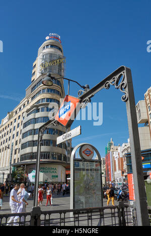 Callao Metro Zeichen Struktur gegen blauen Himmel mit dem legendären Schweppes-Zeichen im Hintergrund. Madrid. Spanien. Stockfoto