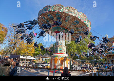 Halloween-Thema in den überfüllten Tivoli Gärten, Kopenhagen, Dänemark. Die Schaukel Karussell oder Chairoplane Fahrt am sonnigen Nachmittag Ende Oktober. Tivoli. Stockfoto