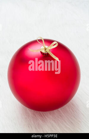 Eine perfekte große rote Christbaumkugel auf weißem Hintergrund vertikale Nahaufnahme Stockfoto