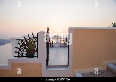 Ein Blick über ein Tor zu einer Terrasse und unten ist das Meer und einen herrlichen Sonnenuntergang Stockfoto