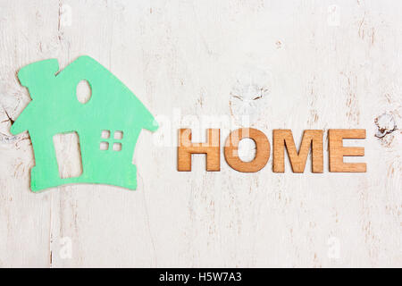 Wort nach Hause Holzbuchstaben und ein grünes Haus auf einem weißen Hintergrund alte hölzerne Stockfoto