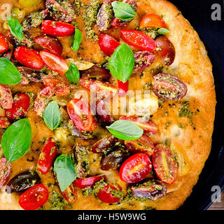 Traditionelle italienische Focaccia mit Tomaten, Basilikum und Pesto. Ansicht von oben Stockfoto