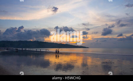 Urlauber am Strand von Jimbaran in Bali, Indonesien, bei Sonnenuntergang. Stockfoto