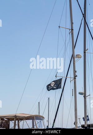 Totenkopf auf Segeln Mast gegen blauen Himmel Stockfoto